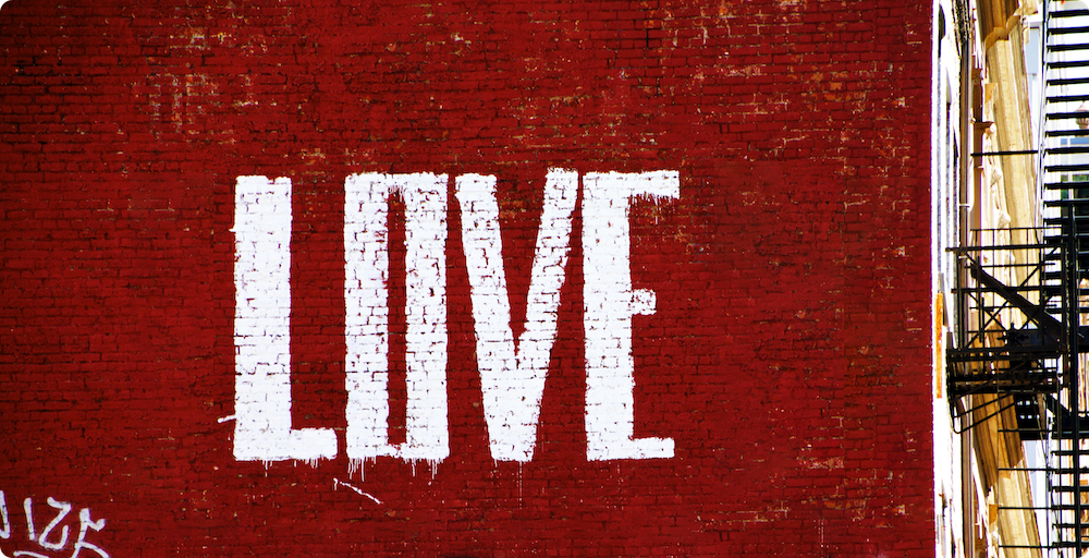 Graffiti on brick wall in New York City reads "love"
